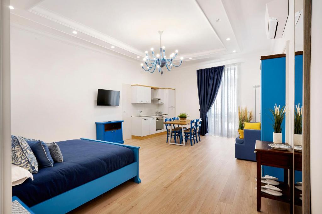 une chambre avec un lit bleu et une salle à manger dans l'établissement Partenope, à Castellammare di Stabia