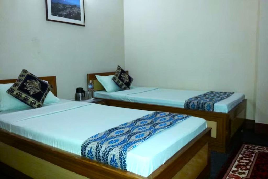 two twin beds in a room at Hotel North Point Darjeeling - Excellent Service Recommended & Couple Friendly in Darjeeling