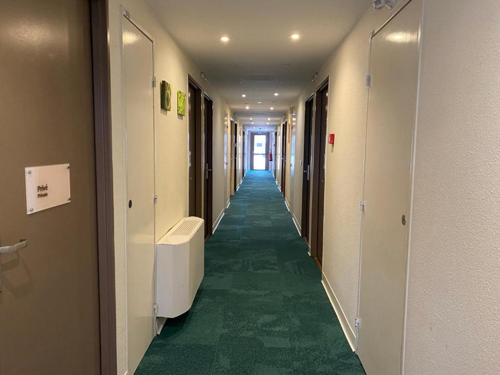 a corridor of a hospital hallway with green floors at Kyriad Montpellier Aéroport - Gare Sud de France in Mauguio