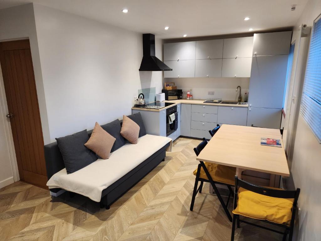 ein Wohnzimmer mit einem Sofa und einem Tisch in der Unterkunft Modern 3 bedroom home in Guildford. Sleeps 8 in Guildford