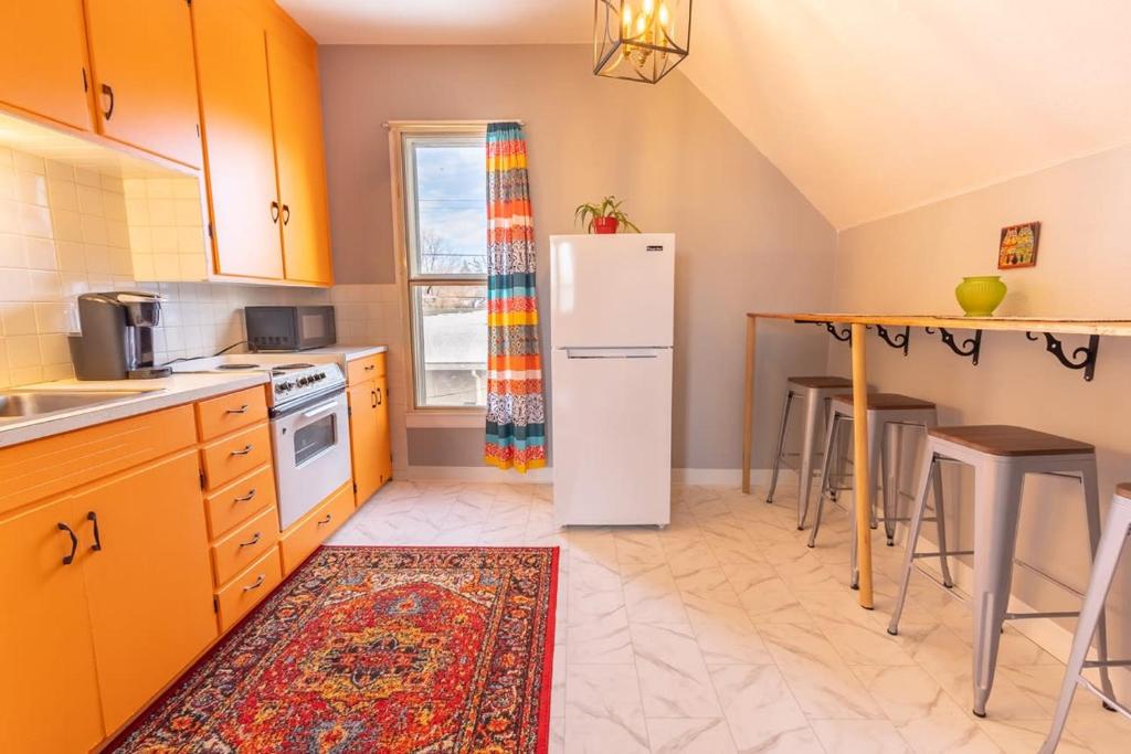 een keuken met een witte koelkast en een tafel bij New Listing!! Bright Bohemian Stay in Laramie