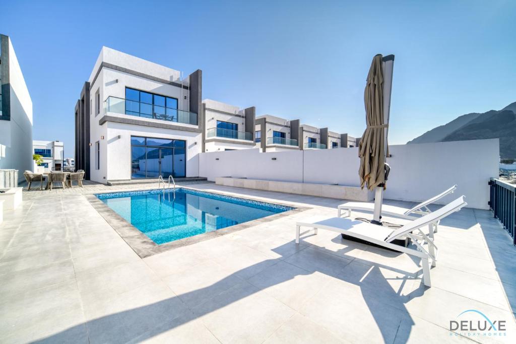 Majoituspaikassa High-end 4BR Villa with Assistant’s Room Al Dana Island, Fujairah by Deluxe Holiday Homes tai sen lähellä sijaitseva uima-allas