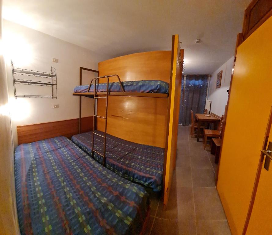 a room with two bunk beds and a table at Appt pied pistes et centre station Superdévoluy chez Locasoleil in Le Dévoluy