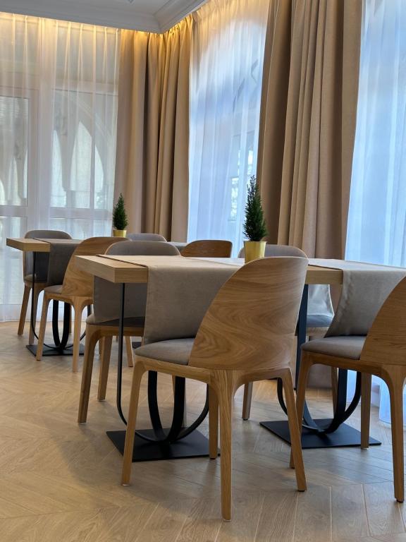 Hotel Antoni في توماسزو لوبليسكي: صف من الطاولات والكراسي في غرفة بها نوافذ