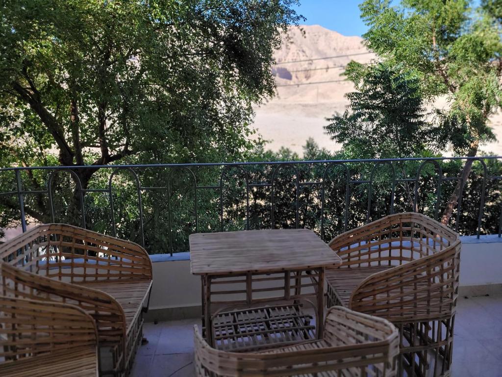 a table and chairs on a balcony with a view of a mountain at Bayt Al Jabal luxor in Luxor
