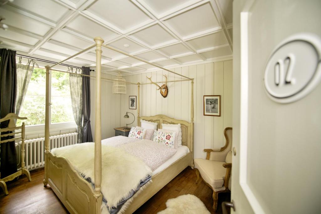 B&B Langenberg في Langnau am Albis: غرفة نوم مع سرير مظلة ونافذة