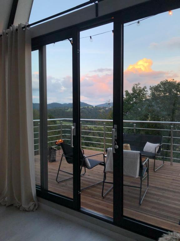 a balcony with sliding glass doors with a view of the mountains at Áčko in Oščadnica