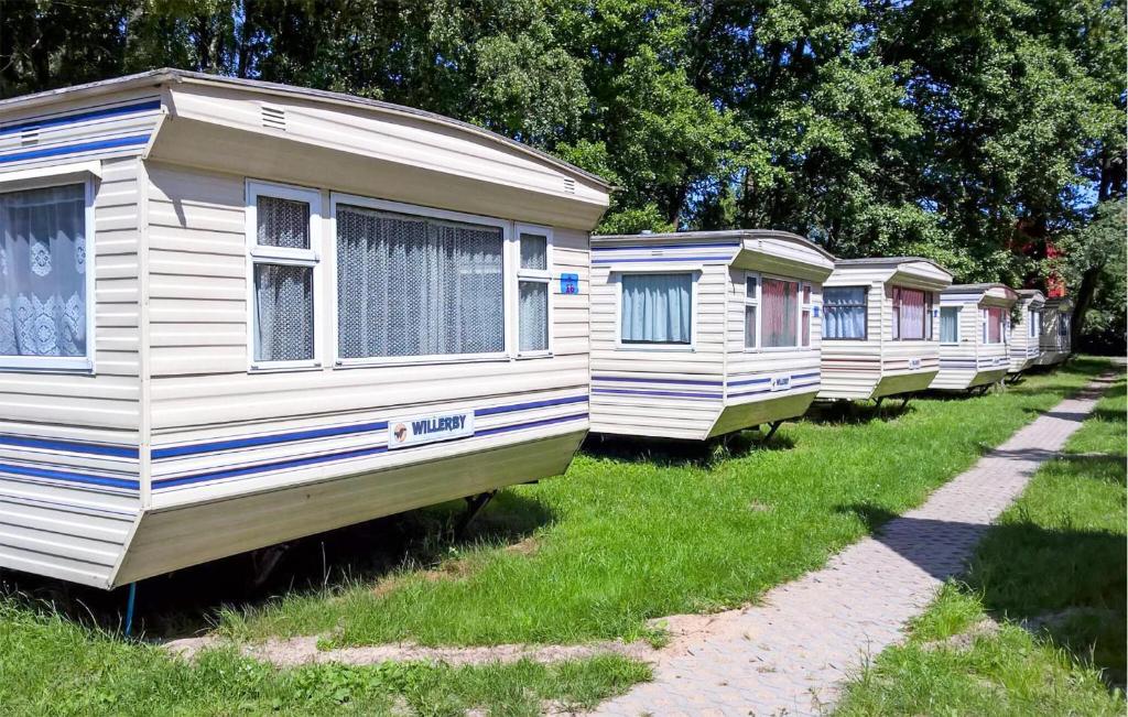 a row of mobile homes parked in the grass at Lovely Home In Mielno With Kitchen in Mielno