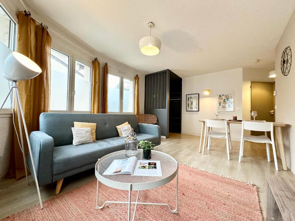 a living room with a blue couch and a table at LE COSY - Plain-Pied in Mont-de-Marsan