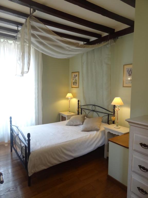 - une chambre avec un grand lit et une fenêtre dans l'établissement Le Pelerine, à Sauveterre