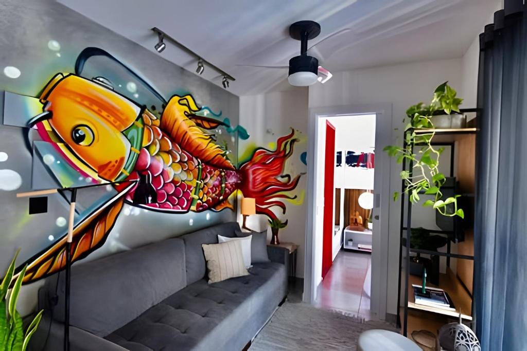 una sala de estar con un mural de pescado en la pared en Exclusivo na Liberdade com Piscina e Wi-fi 300mb, en São Paulo