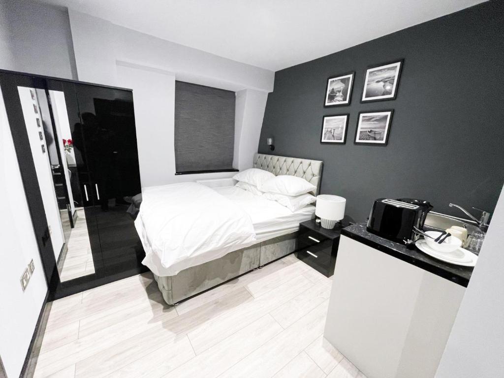 1 dormitorio con 1 cama y lavamanos. en Letzi Private En-Suite In Harrow, en Pinner