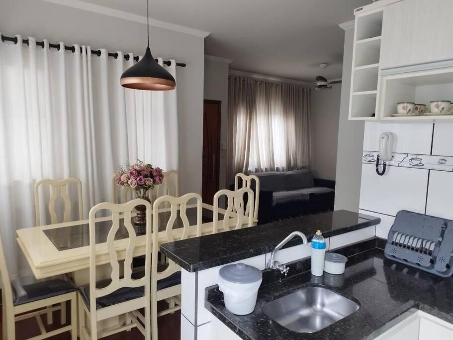 a kitchen with a sink and a table with chairs at Residencia Cidade Verde 1 Ourinhos in Ourinhos