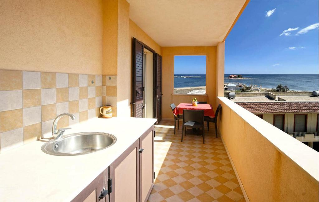 een keuken met een wastafel en uitzicht op de oceaan bij Amazing Apartment In Marzamemi With House A Panoramic View in Marzamemi