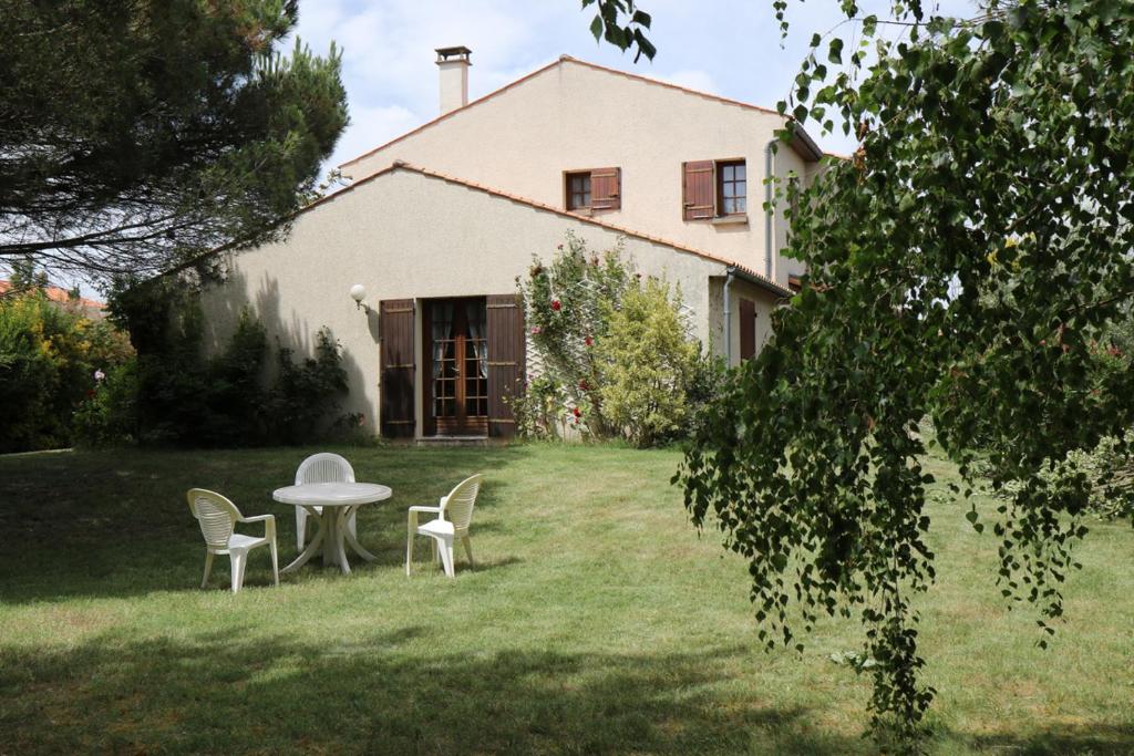 uma mesa e cadeiras no quintal de uma casa em Chez Pierrot et Gisele em Meschers-sur-Gironde