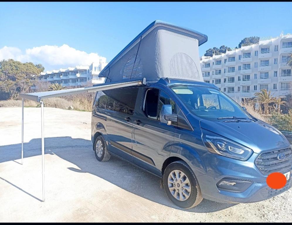 Ford Transit Custom Camper في بالما دي ميورقة: وجود سيارة فان زرقاء فوقها