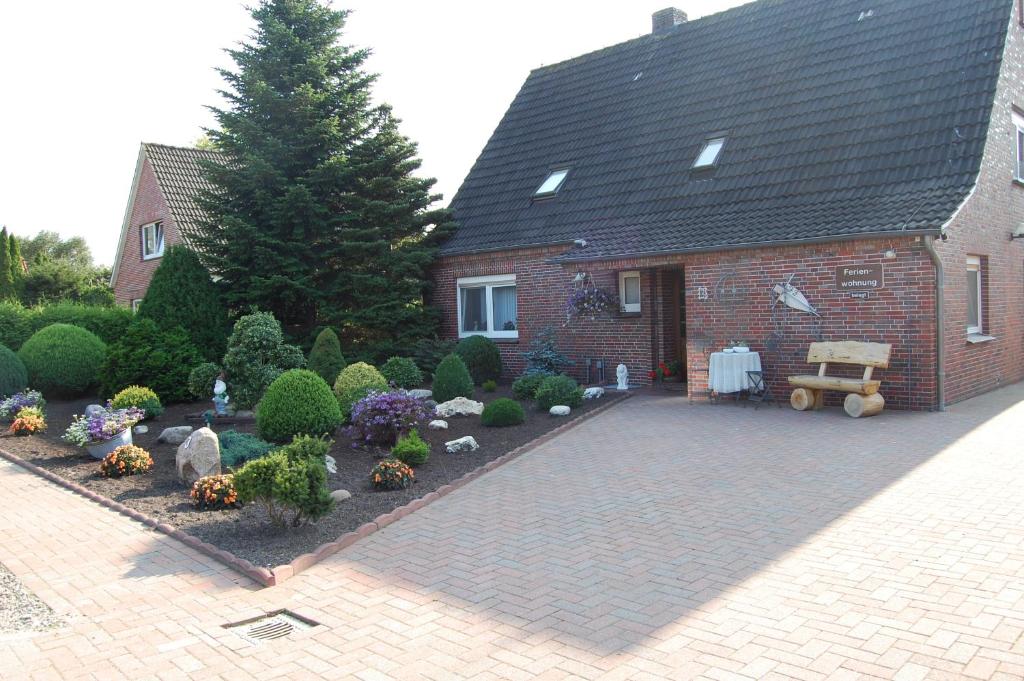 einen Garten vor einem Backsteinhaus in der Unterkunft Haus Resi in Wiesmoor