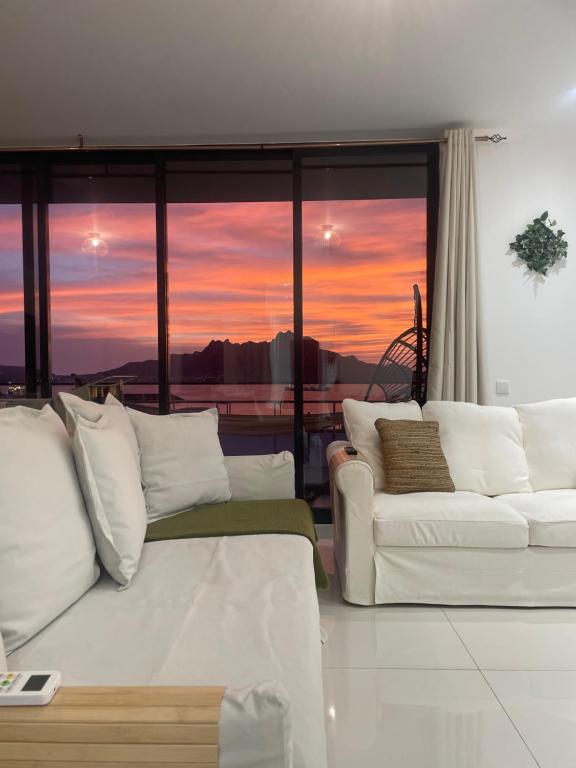 a living room with a couch and a sunset at Ocean View Santa Filomena in Mindelo