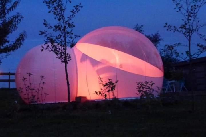 two large spheres are lit up at dusk at La bulle 