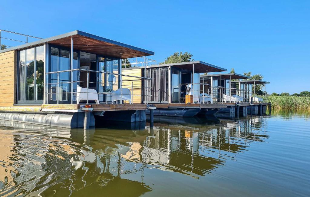 una casa en un muelle sobre un cuerpo de agua en Cozy Ship In Mielno With Kitchen en Mielno