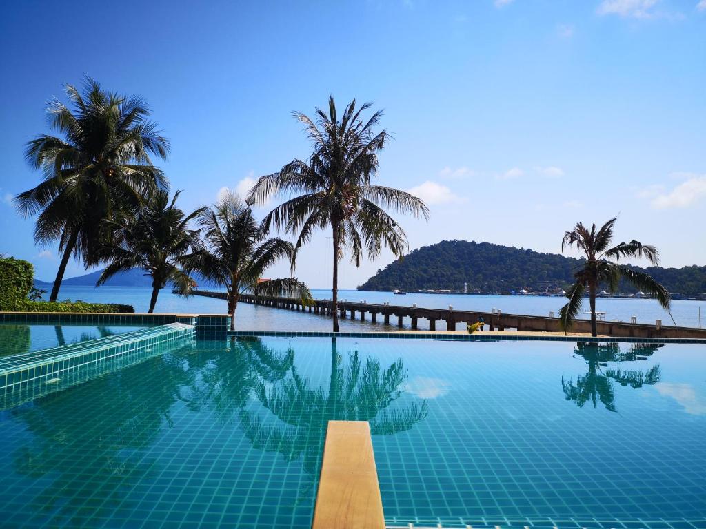 una piscina con palme e vista sull'oceano di Koh Chang Appartment 2 bedrooms a Ban Bang Bao