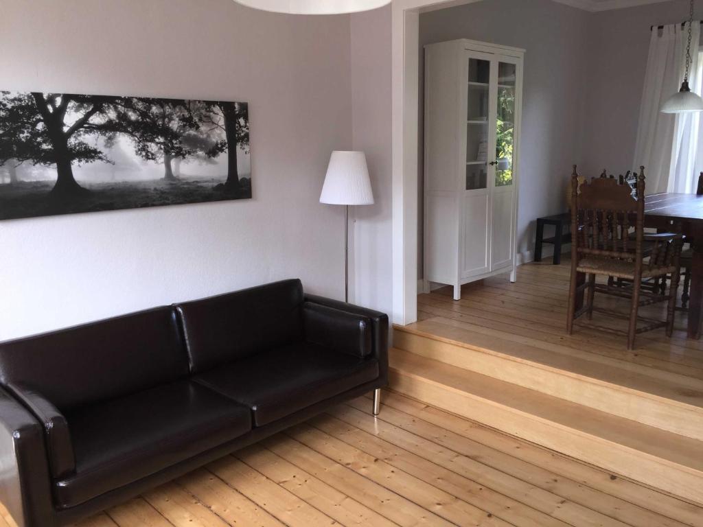 sala de estar con sofá negro y mesa en Gästehaus Stadt Land Fluss, 