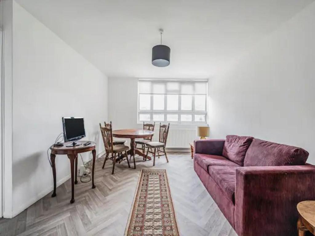 a living room with a couch and a table at Pass the Keys Spacious Apartment in Honor Oak in London