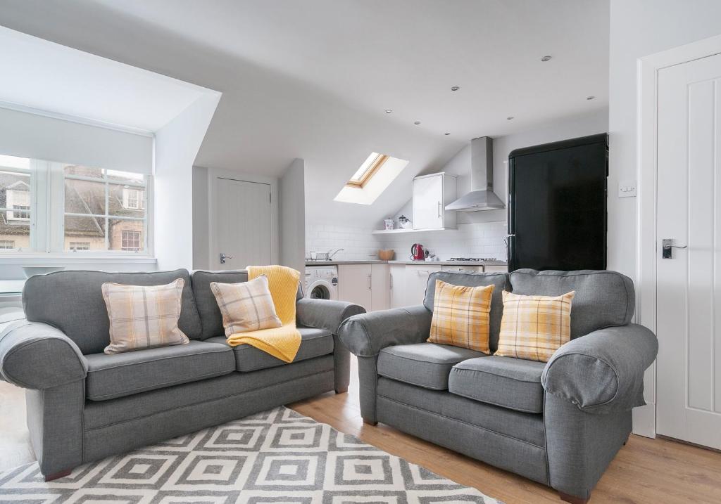 a living room with two couches and a tv at High Street Apartment in Edinburgh