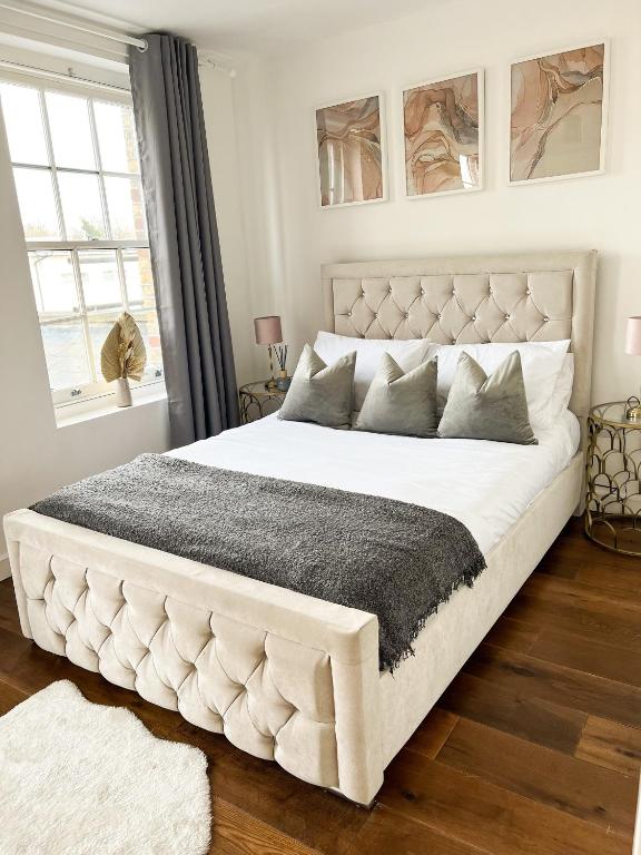 un grande letto bianco in una camera da letto con finestra di London Stylish 1 Bedroom Apartment a Londra