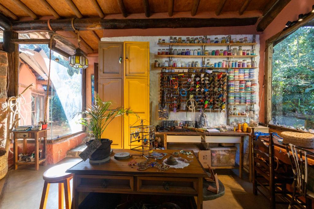 a kitchen with a table and a yellow wall at Casa Atelie Bangue in Ilhabela