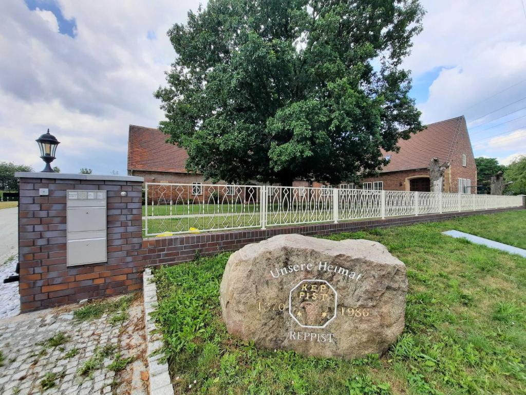a rock in the grass next to a fence at Seenlandoase Reppist in Senftenberg