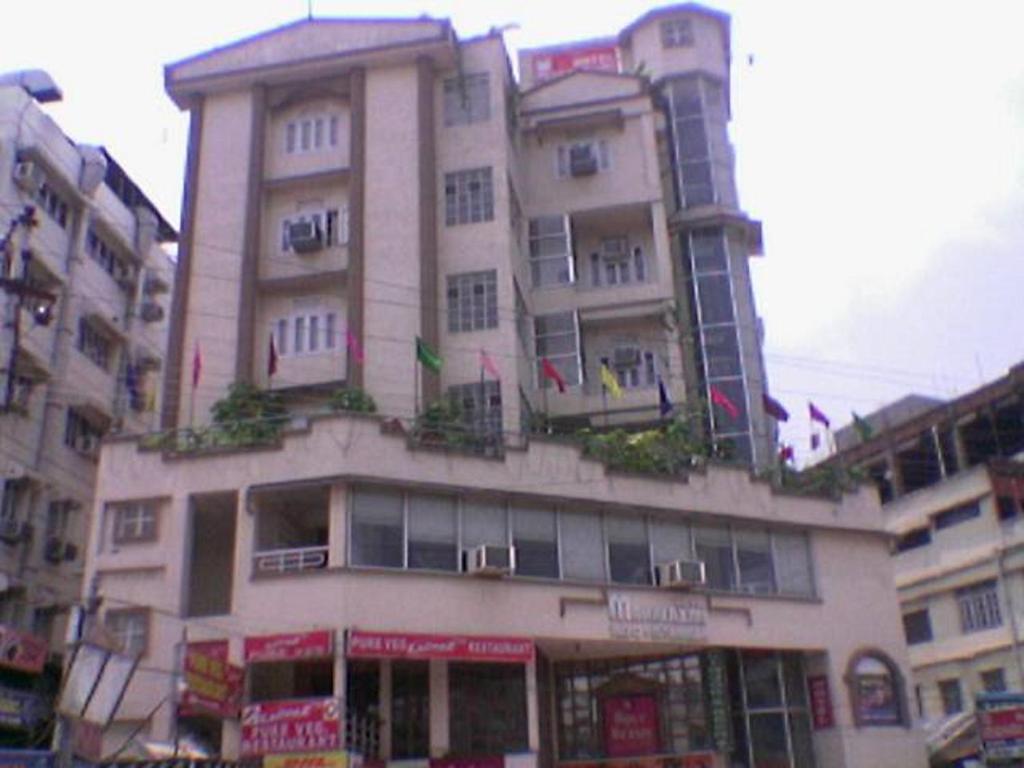 ein hohes Gebäude mit Flaggen darüber in der Unterkunft Hotel Mahalaxmi Indo Myanmar in Guwahati