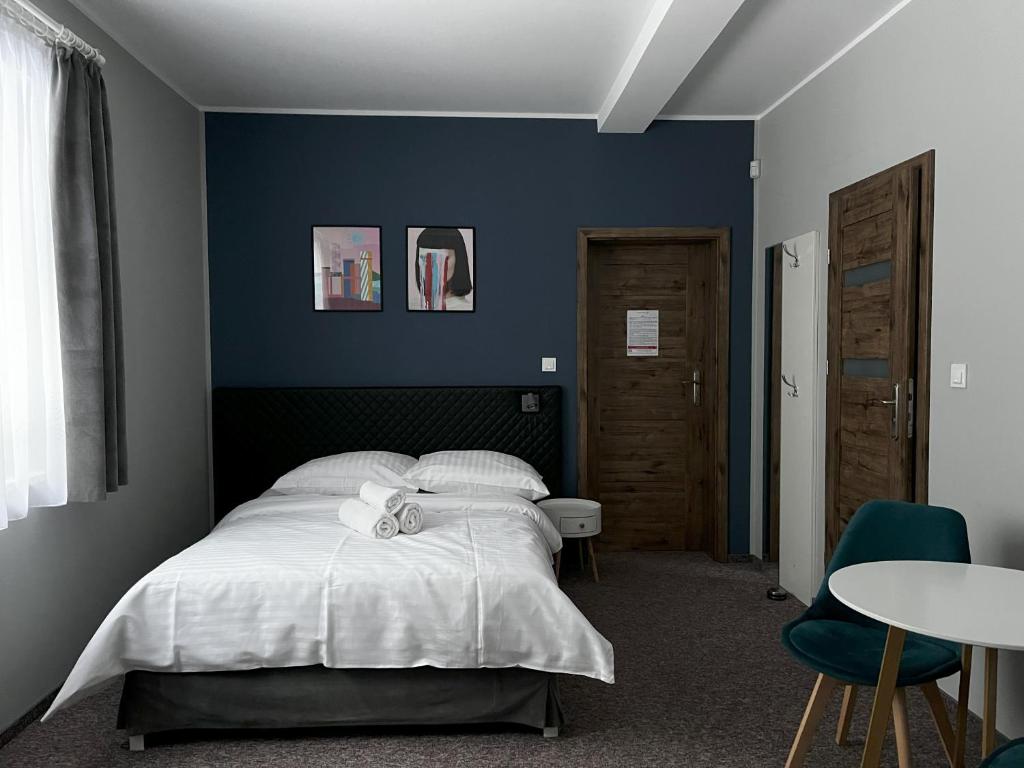 a bedroom with a bed and a blue wall at Apartamenty Wypoczynkowa 24 - 700m od Park Wodny Suntago Wręcza in Krzyżówka