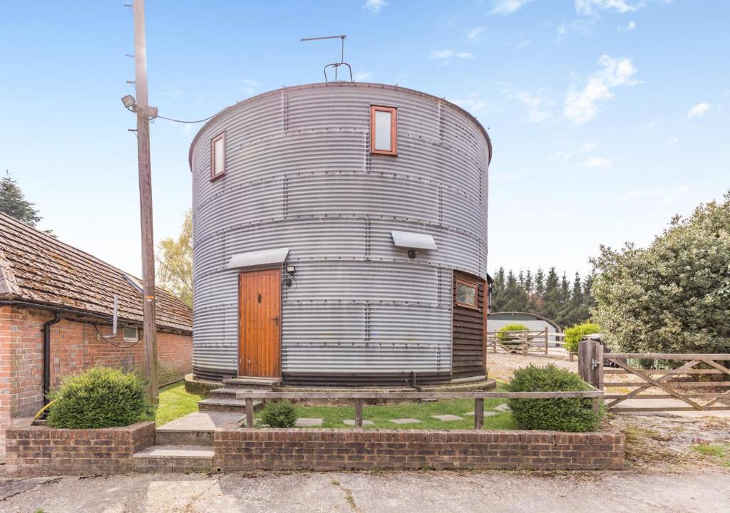 a round silo with a wooden door on a house at The Corn Bin in Sedlescombe