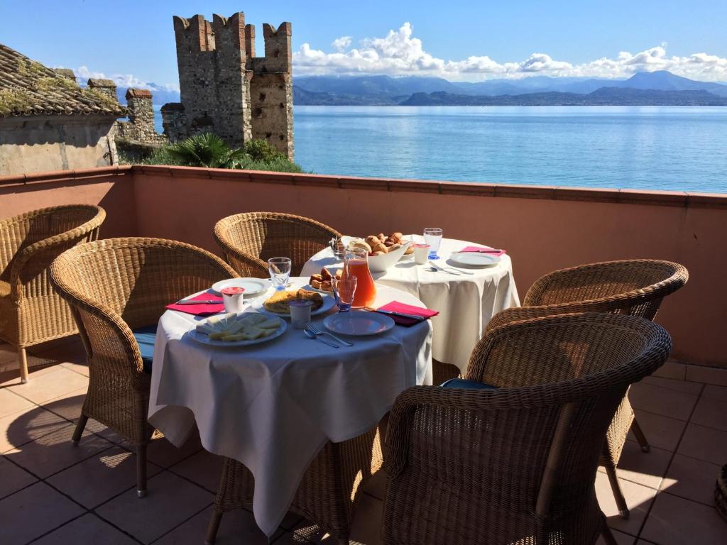 a table on a balcony with a view of a castle at Hotel Degli Oleandri in Sirmione