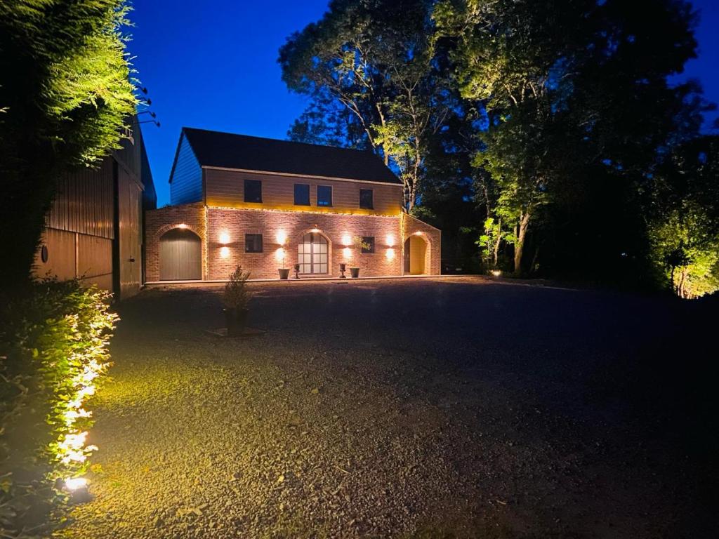 dom z lampkami na boku w nocy w obiekcie Horse Lodge de Bélian w mieście Hannut