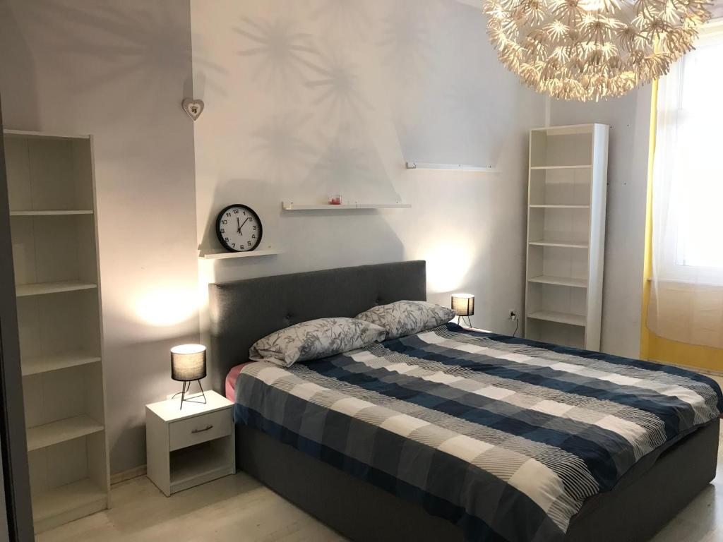 - une chambre avec un lit doté d'une horloge et d'un lustre dans l'établissement River City Apartments, à Rijeka