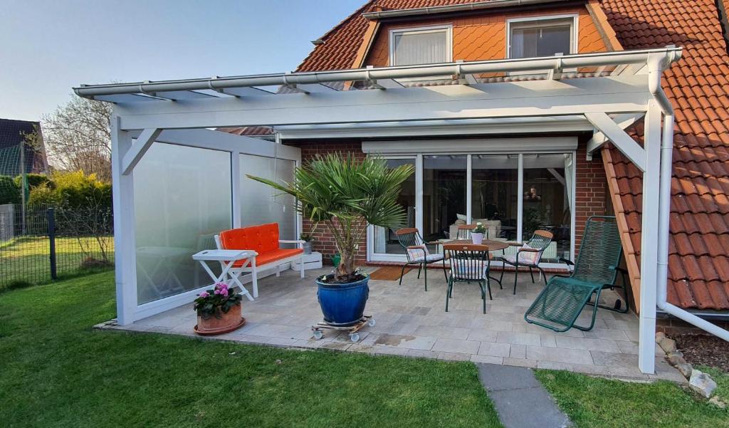 a pergola with a table and chairs on a patio at Sonnenkoje in Apensen