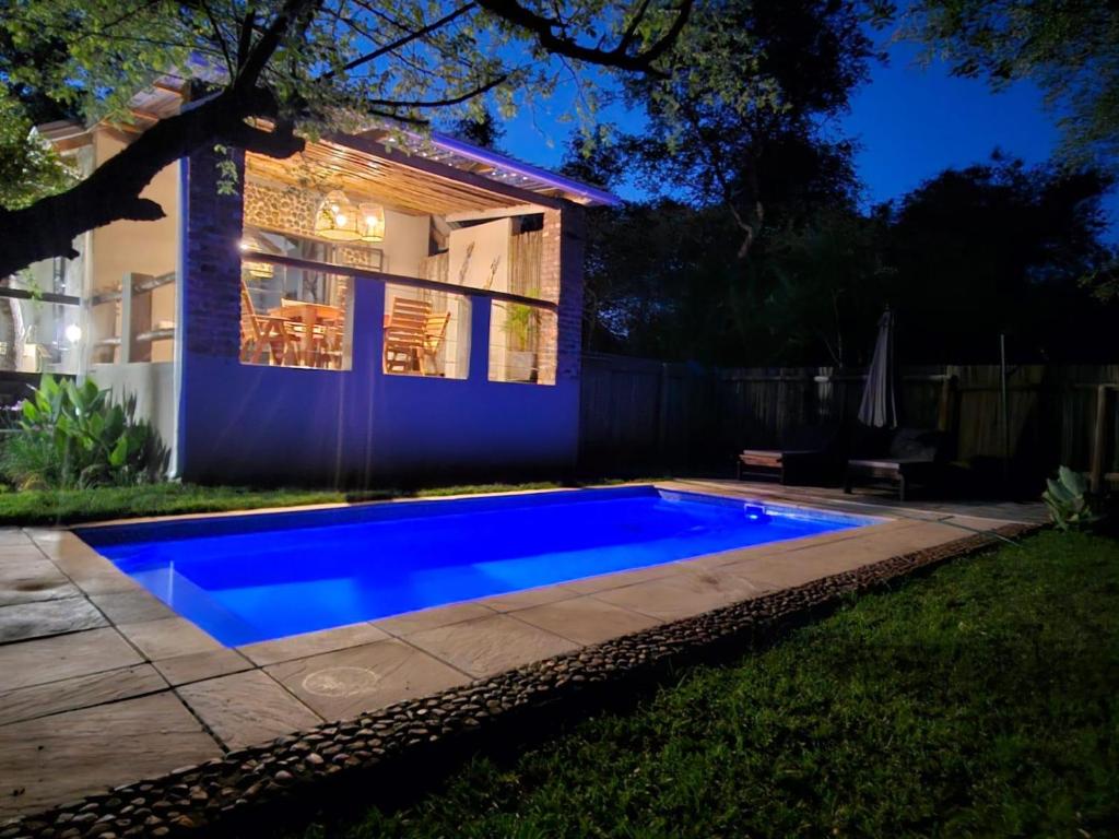 a blue swimming pool in front of a house at The Blyde Canyon House in Hoedspruit