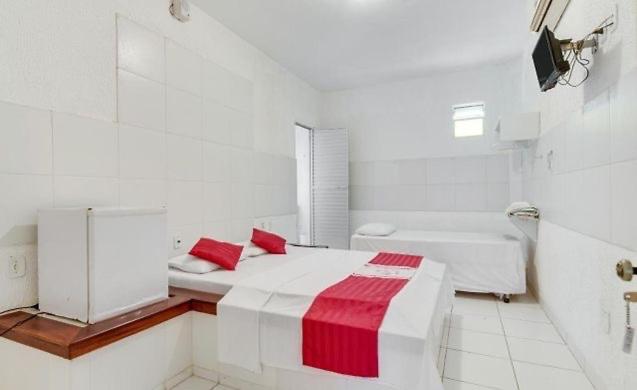 a white bathroom with a bed and a bath tub at HOTEL PRESIDENTE in Belém