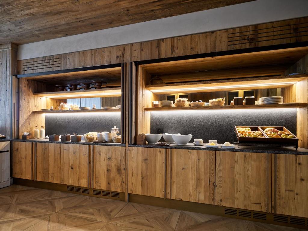 a kitchen with wooden cabinets with food on display at Cervino - VRetreats in Breuil-Cervinia