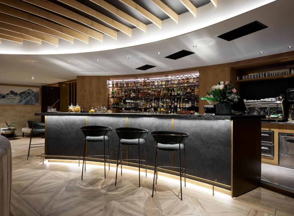 a bar in a restaurant with stools at a counter at Cervino - VRetreats in Breuil-Cervinia