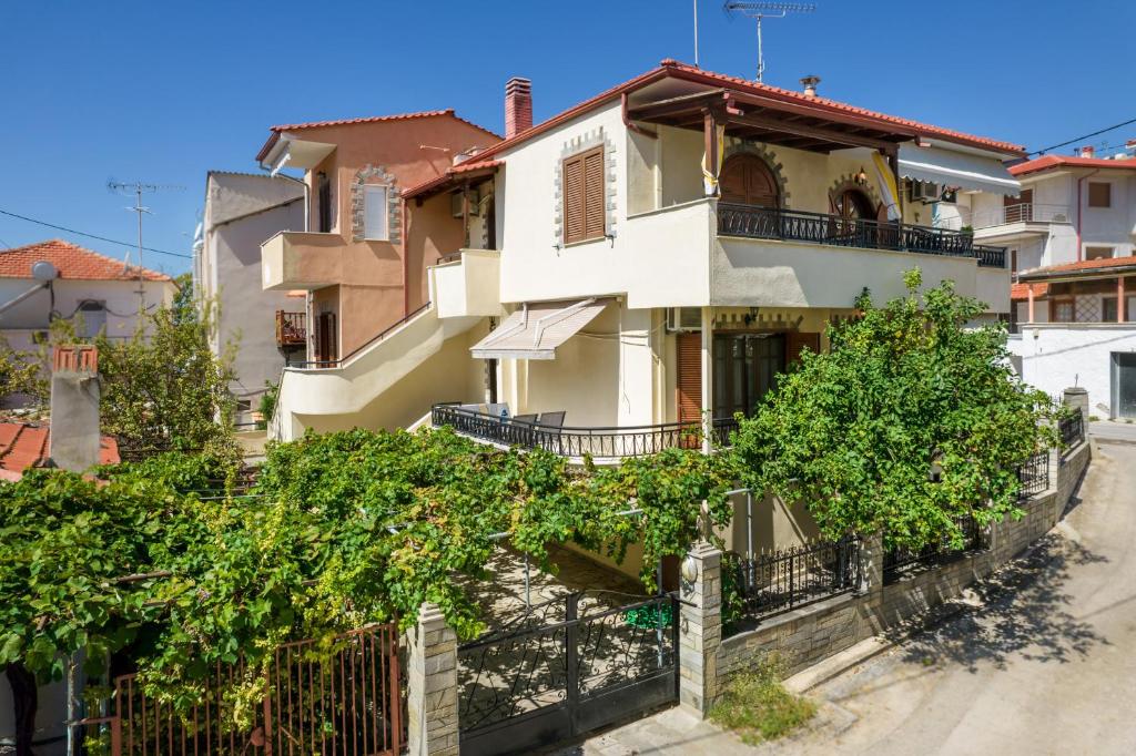 a white house with trees in front of it at Studios Anagnostou in Skala Marion