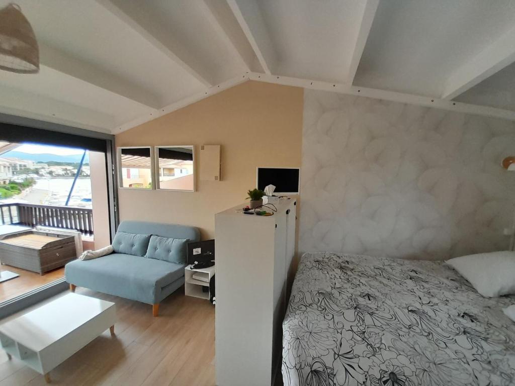 sypialnia z łóżkiem i kanapą w obiekcie Spacieux Studio 3pers vue marina a St Cyprien w mieście Saint-Cyprien