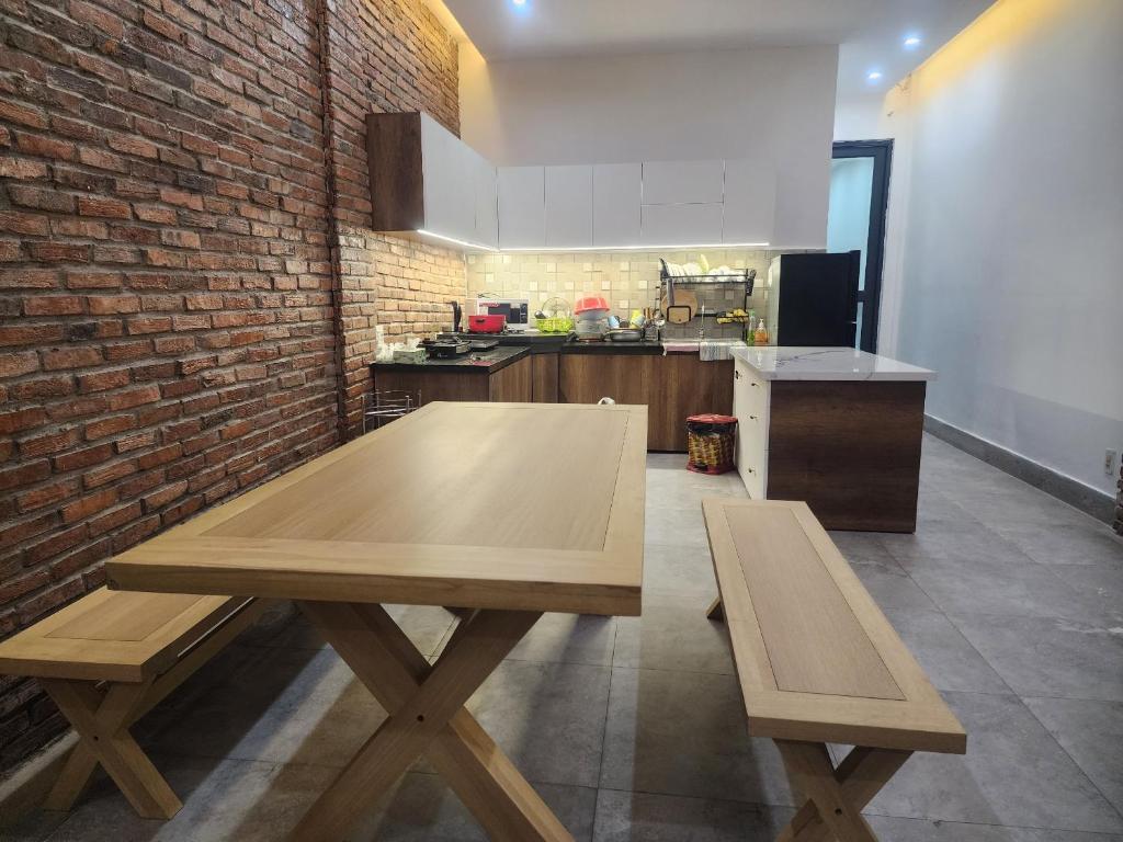 cocina con mesa de madera y pared de ladrillo en T-House, en Can Tho