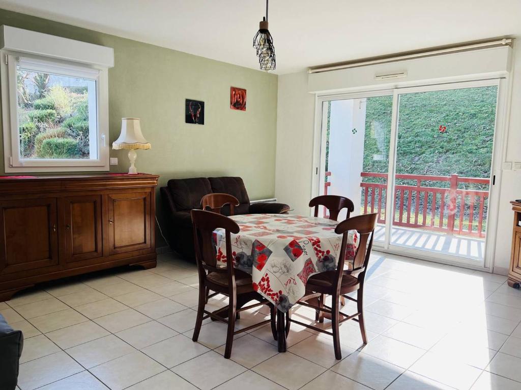 un salon avec une table et des chaises et un balcon dans l'établissement Confortable T2 avec terrasse, parking, et internet à Cambo-les-Bains, proche thermes et centre - FR-1-495-95, à Cambo-les-Bains