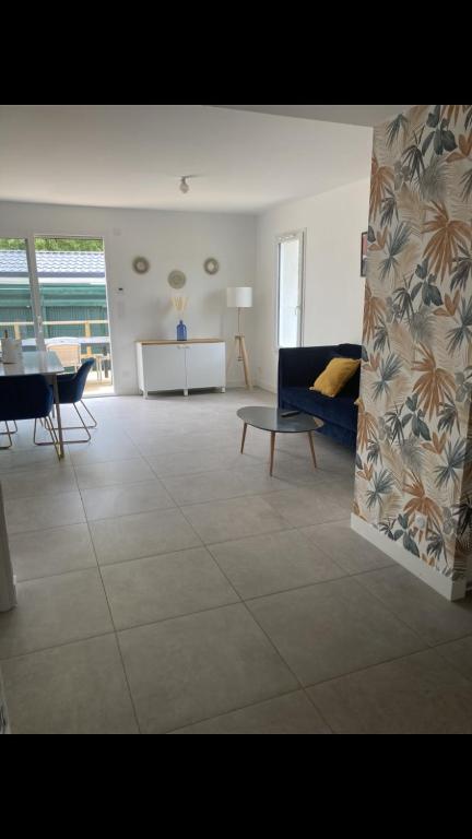 un salon avec un canapé bleu et une table dans l'établissement Maison 2 chambres, à Cambo-les-Bains