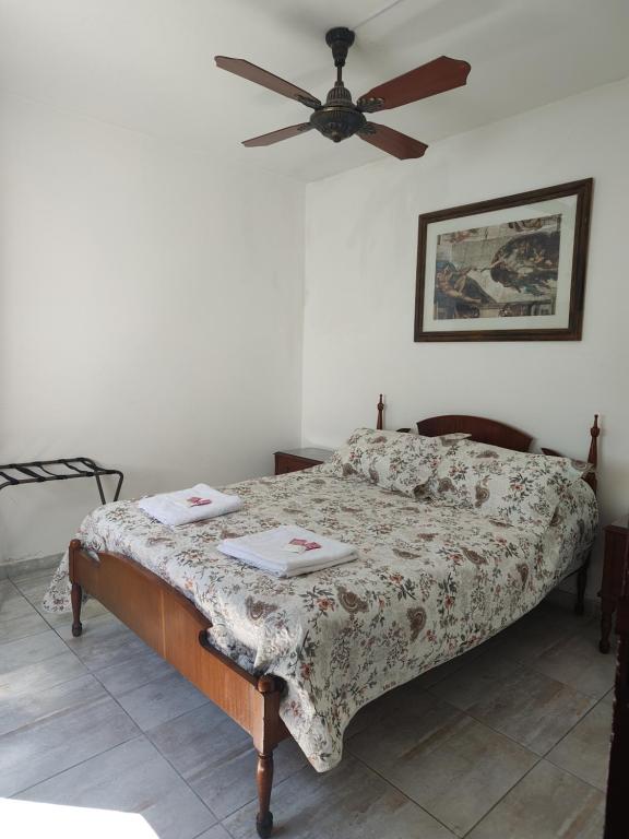 - une chambre avec un lit et un ventilateur de plafond dans l'établissement Departamento Costanera Alta Gracia, à Alta Gracia