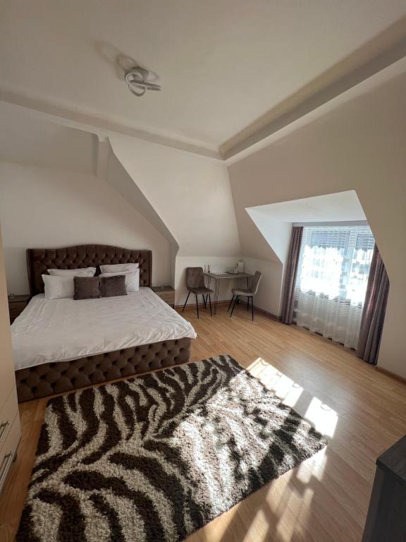 1 dormitorio con cama y alfombra en el suelo de madera en Central Studio 28, en Sinaia