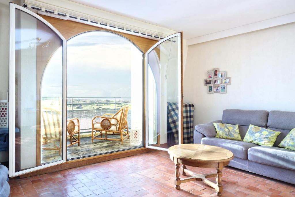 d'un salon avec un canapé et un balcon. dans l'établissement L'Abri du Repos - Appt vue sur le port, à Barneville-Carteret